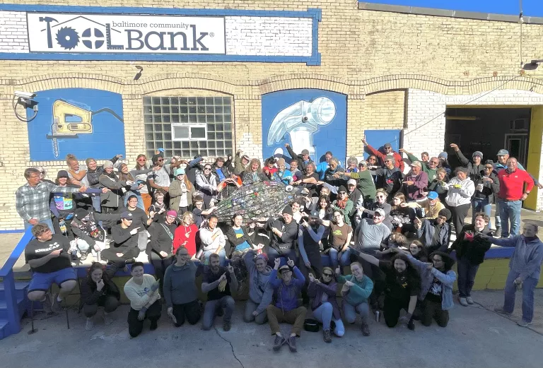 Dumpster dive volunteers point to Rocky the rockfish, who holds more than 800 of the nearly 3,000 beverage containers found in Mr. Trash Wheel’s dumpster. 