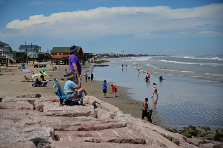 people on the beach in the sand and water