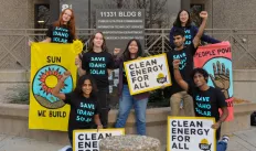 activists holding clean energy for all signs outside of the public utilities commision