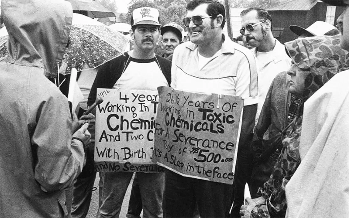 Two men hold protest signs