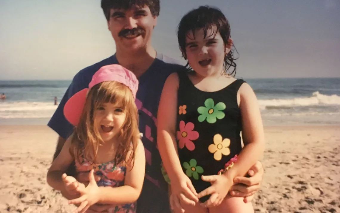 Two sisters and their dad at the beach.