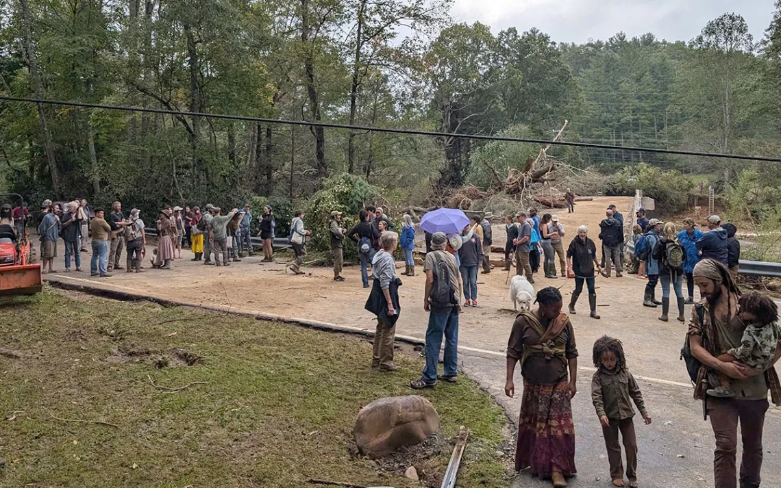 Following Hurricane Helene, Celo members at the destroyed bridge that leads into the community. Residents crossed by ladder seen in back right.