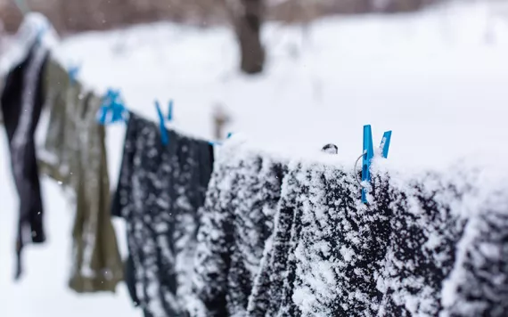 Snow-covered clothes on a clothesline. Photo by Kateryna Kukota | iStock.