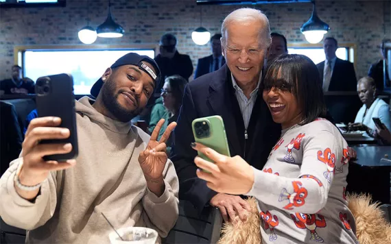 President Joe Biden, center, takes photos with patrons at They Say restaurant during a campaign stop