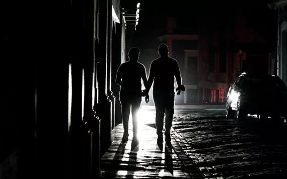 People walk through San Juan during a power outage.