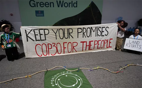 Protestors hold a sign that says, "Keep your promises COP30 for the people"