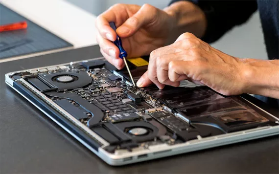 Man repairing laptop with screwdriver