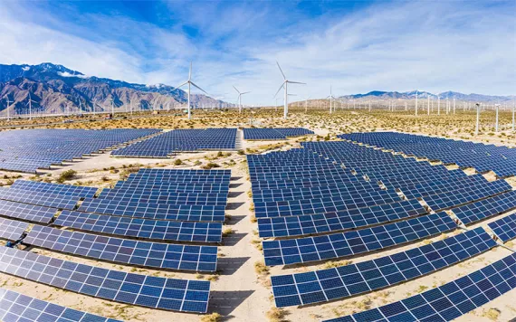 A field of solar panels and windmills in the desert. | Photo by adamkaz/Getty Images