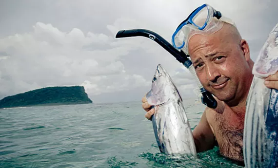 Andrew holds two tuna fish in Samoa. | Courtesy of the Travel Channel
