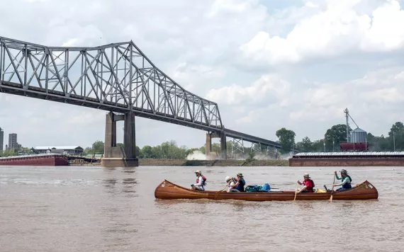 Paddling a handmade canoe under a bridge in Helena, Arkansas, en route from St. Louis to the mouth of the Mississippi.