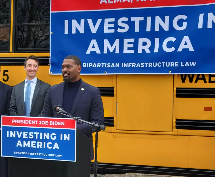 white man and black man in front of yellow electric bus in Alma KS