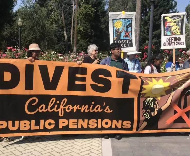 A group of activists hold a poster reading "DIVEST California's Public Pensions."