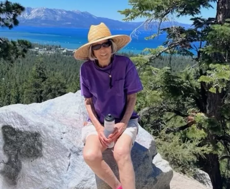 Laurel Ames sitting on a rock with Lake Tahoe behind her. 