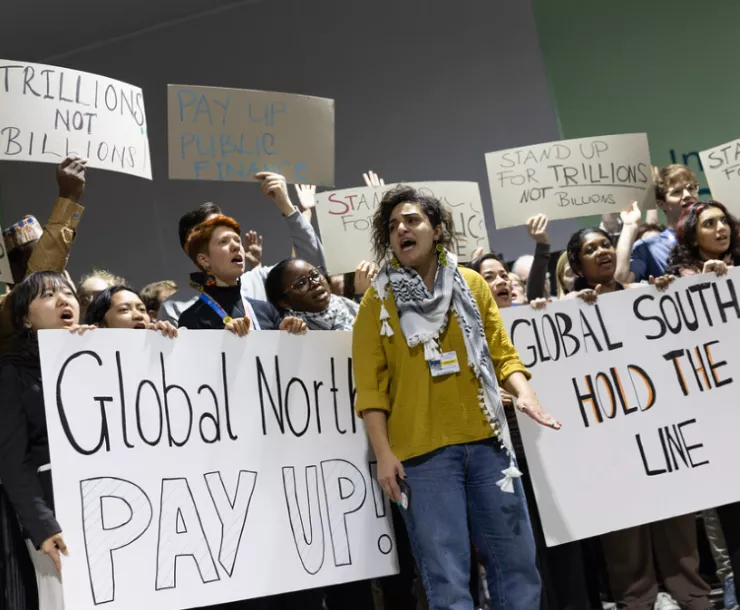 Protesters assembled at COP-29 demanding climate justice with signs