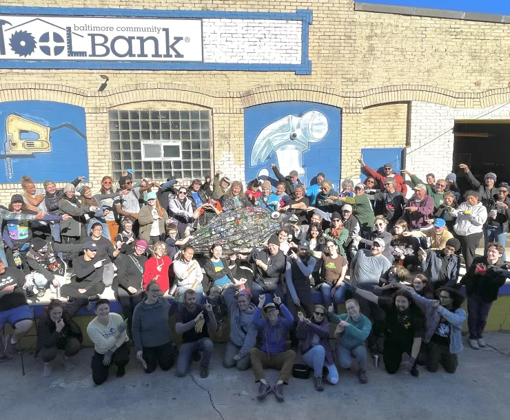 Dumpster dive volunteers point to Rocky the rockfish, who holds more than 800 of the nearly 3,000 beverage containers found in Mr. Trash Wheel’s dumpster. 