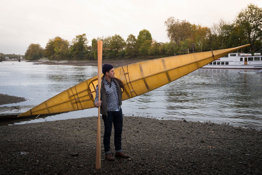 A student readies his finished kayak for the water.