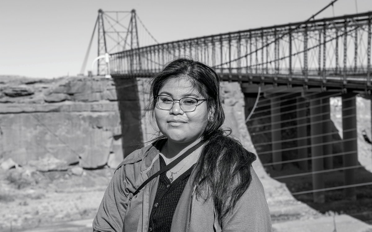 Lisa Semallie-Robbins, wearing glasses, stands before a bridge